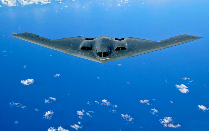 B-2 bomber flying over clouds and water