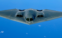 B-2 bomber flying over clouds and water
